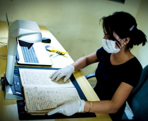 numérisation d'un document historique avec un des scanners surplombants financés par PALOC